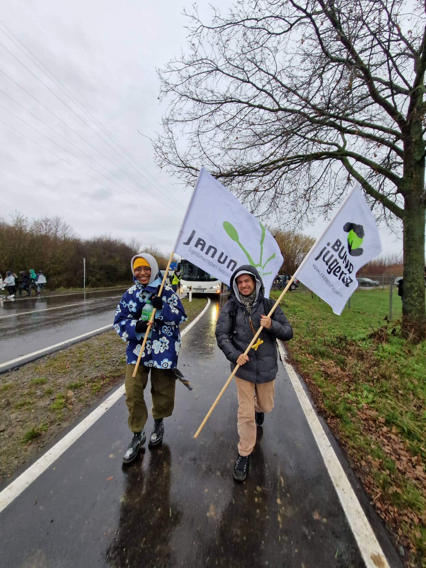 Zwei Menschen mit Fahnen bei einer Demonstration