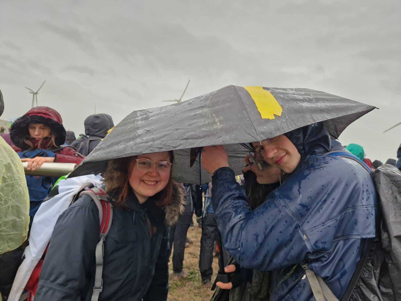 Personen unter Regenschirm bei windiger Wetterlage