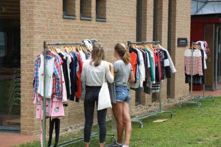 Zwei Frauen shoppen Kleidung draußen.