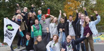 Gruppe feiert mit Fahne im Freien.