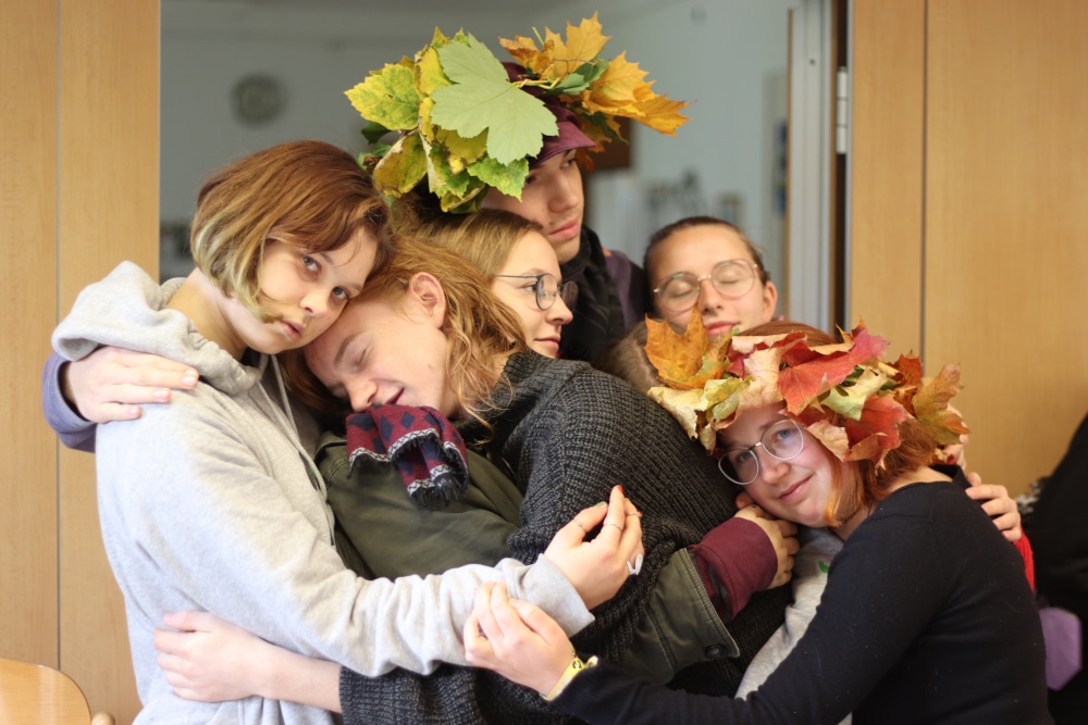 Gruppe von Menschen mit Herbstblättern auf dem Kopf.