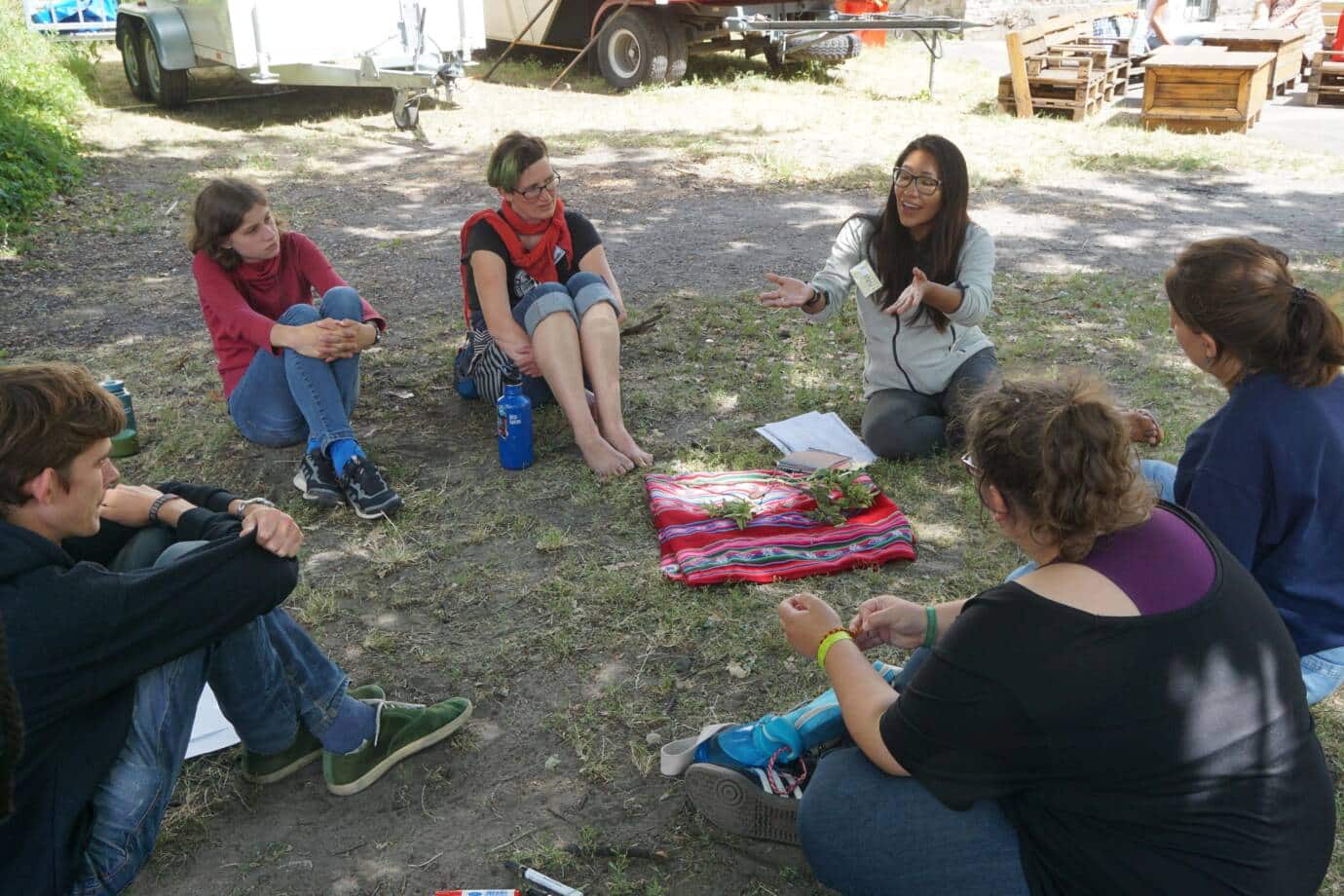 Menschen sitzen im Kreis beim Outdoor-Workshop