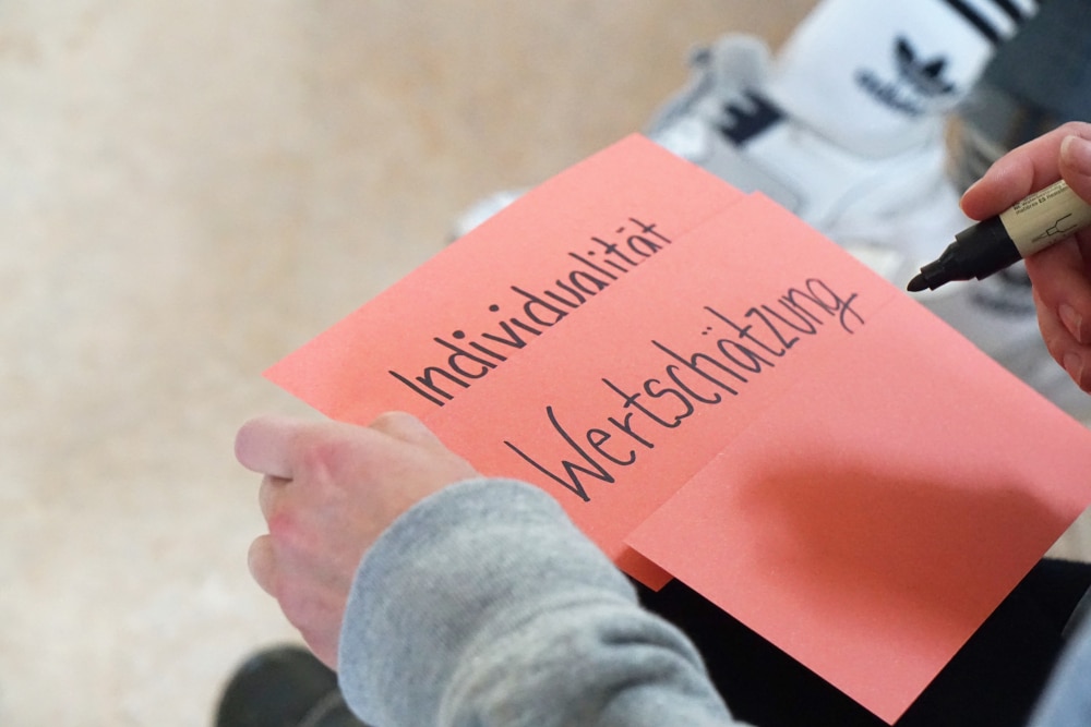 Person hält Karte mit schriftlichen Werten.