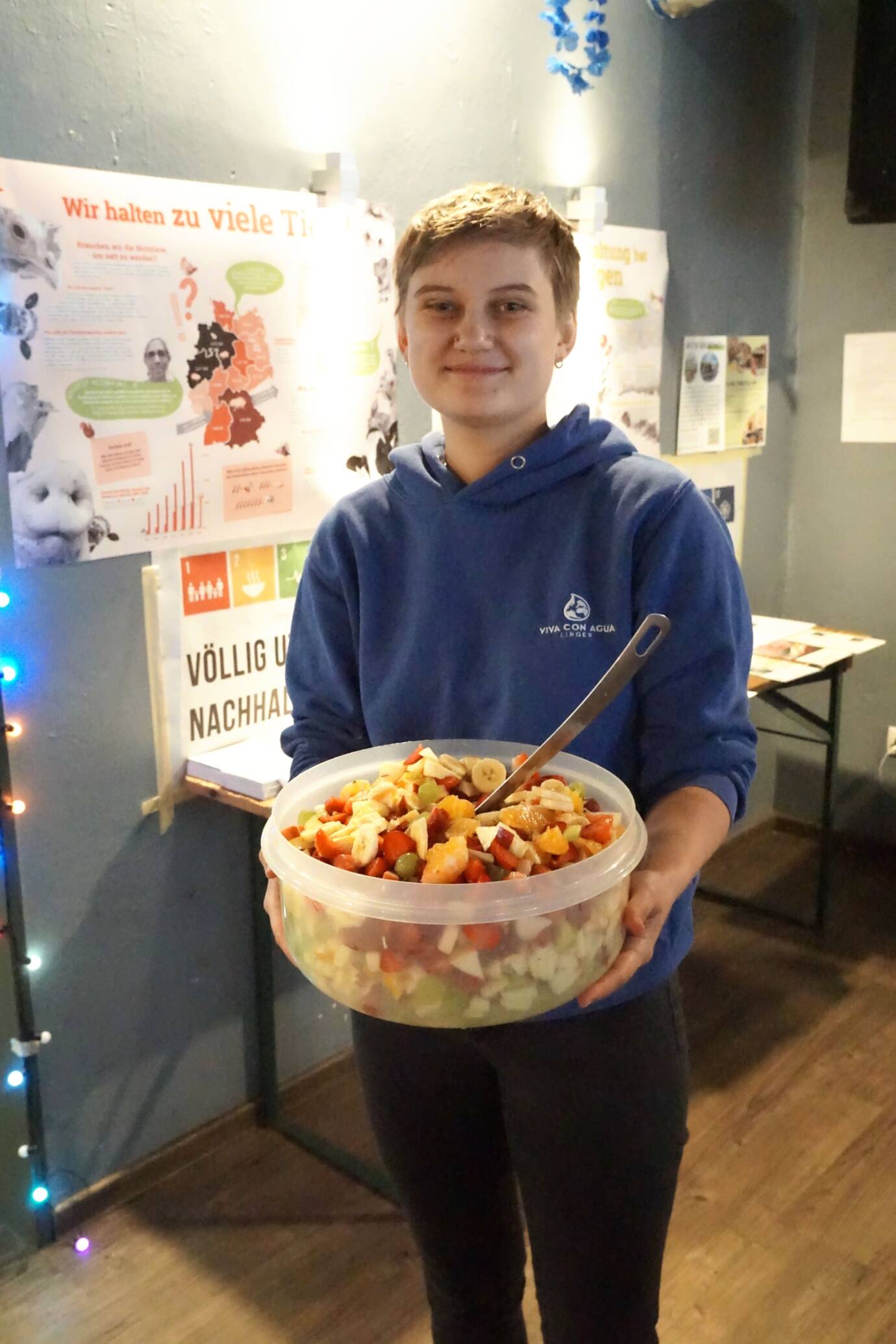 Person mit Salatschüssel vor Poster