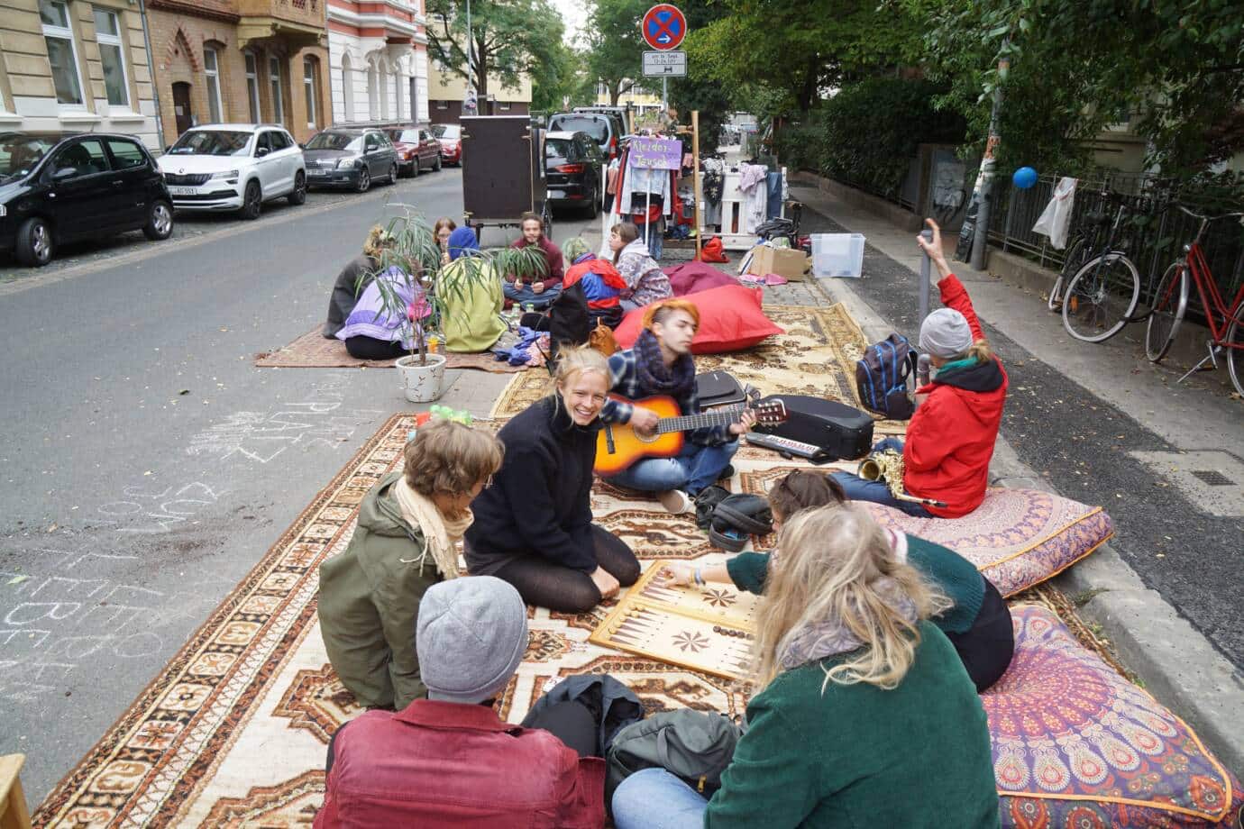 Menschen sitzen auf Teppichen auf der Straße.