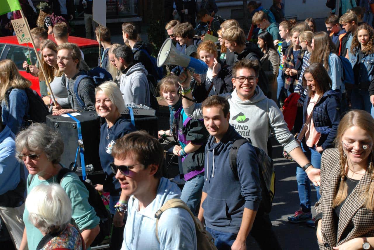 Gruppe junger Menschen bei einer Demo im Freien.