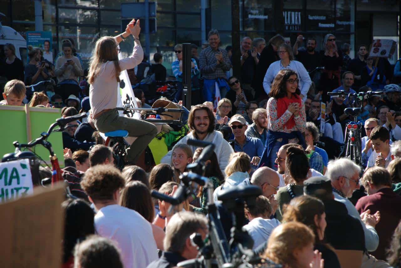 Menschenmenge bei Umweltprotest mit Fahrrädern.