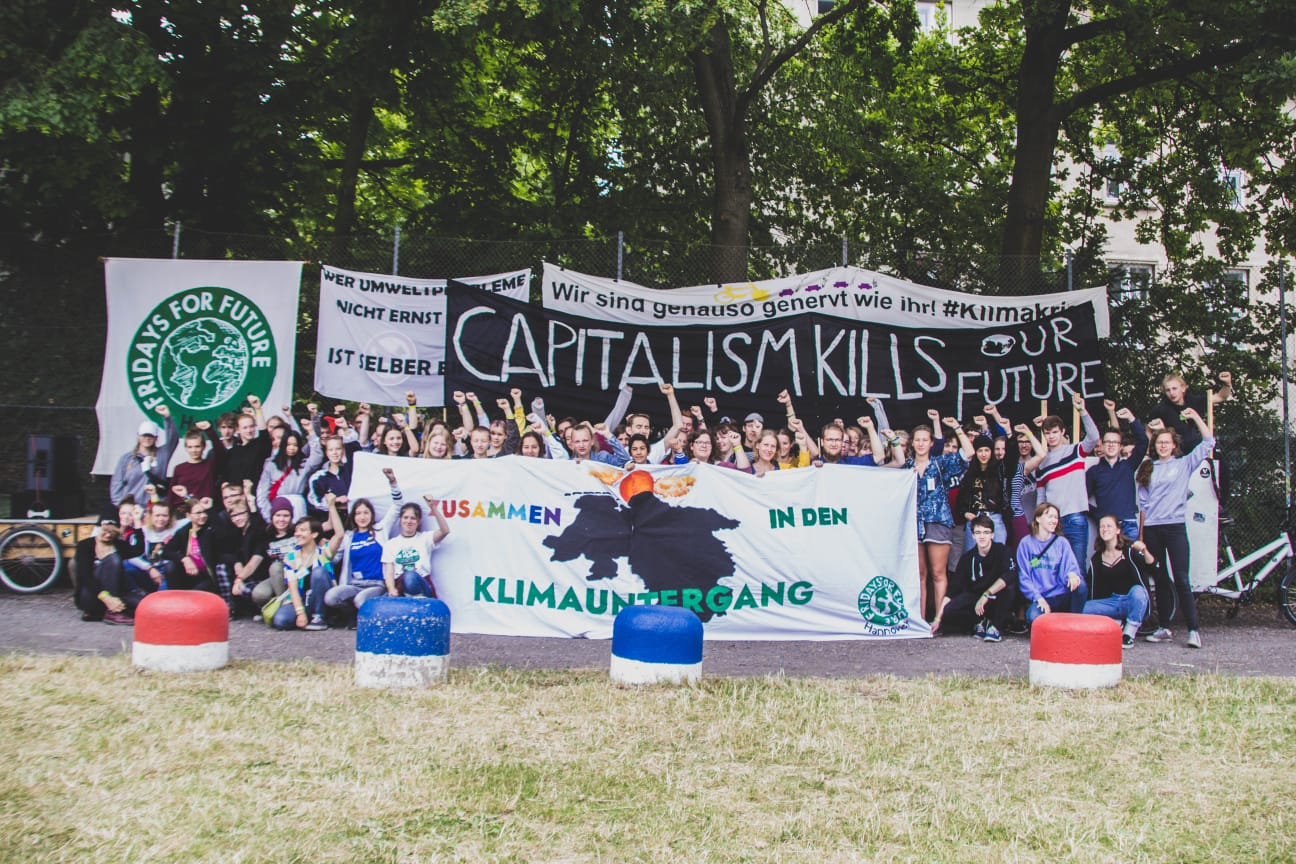 Umweltaktivisten bei Protest mit Bannern im Freien.