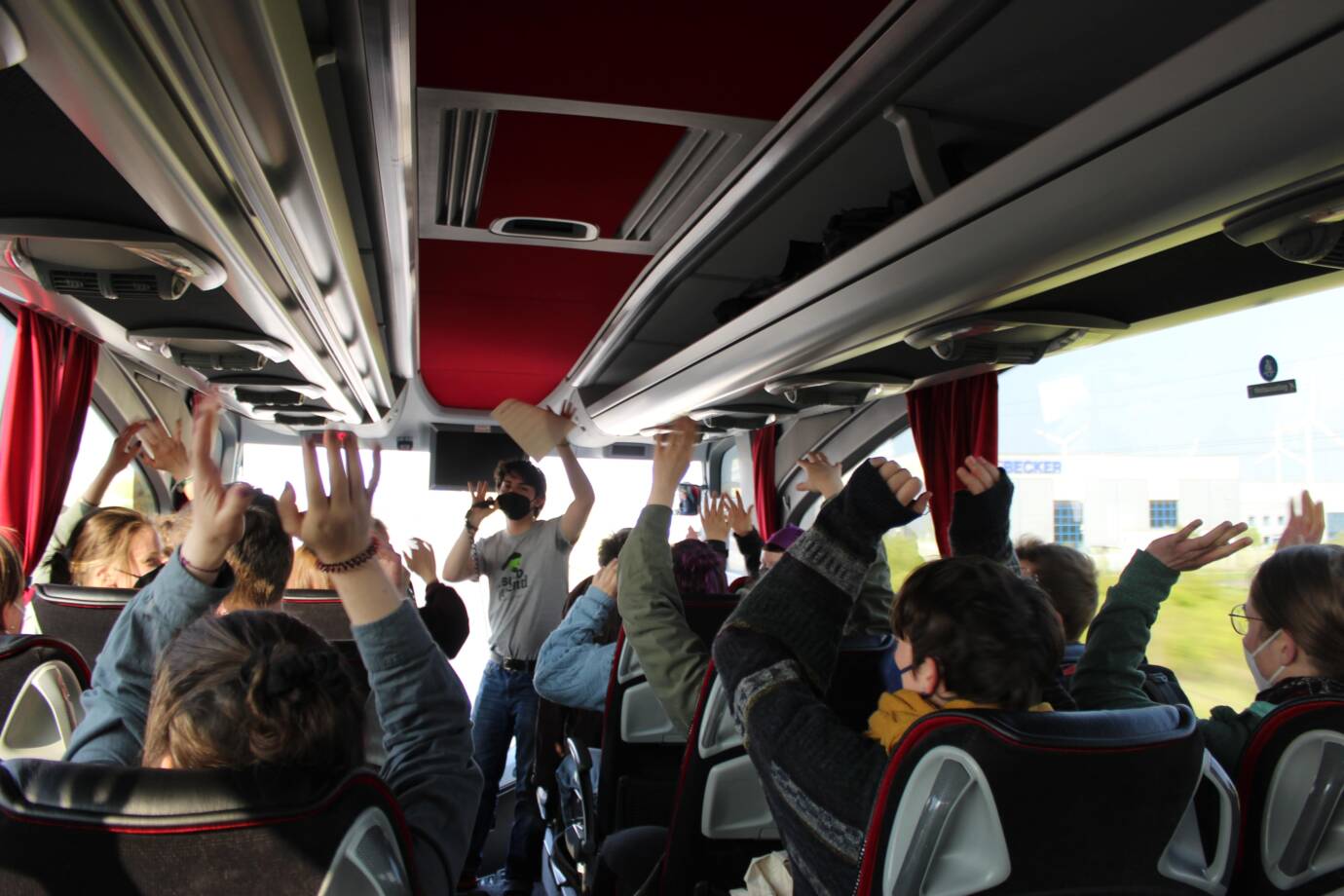 Menschen heben Hände im Bus.