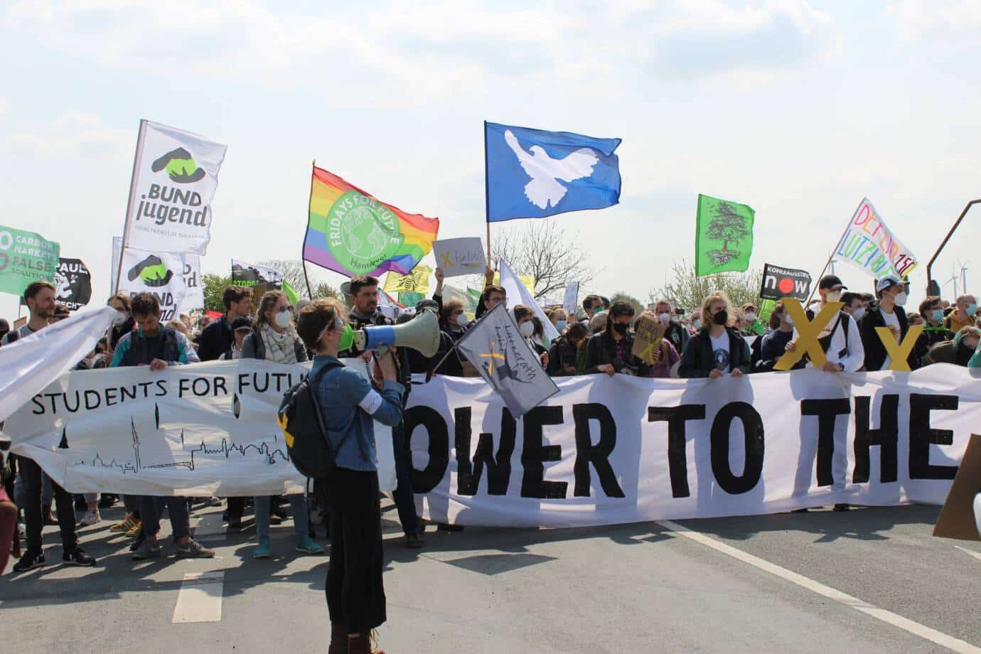Menschen bei einem Klimaprotest mit Bannern und Schildern.