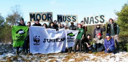 Gruppe mit Bannern im Moor protestiert