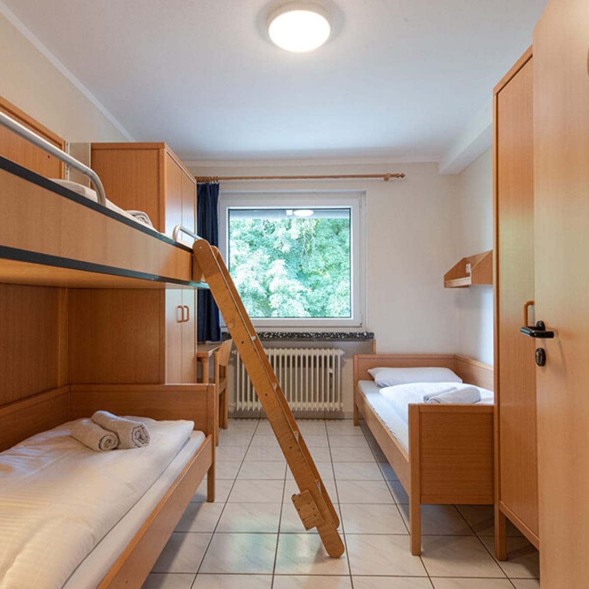 Helles Zimmer mit Stock- und Einzelbett.
