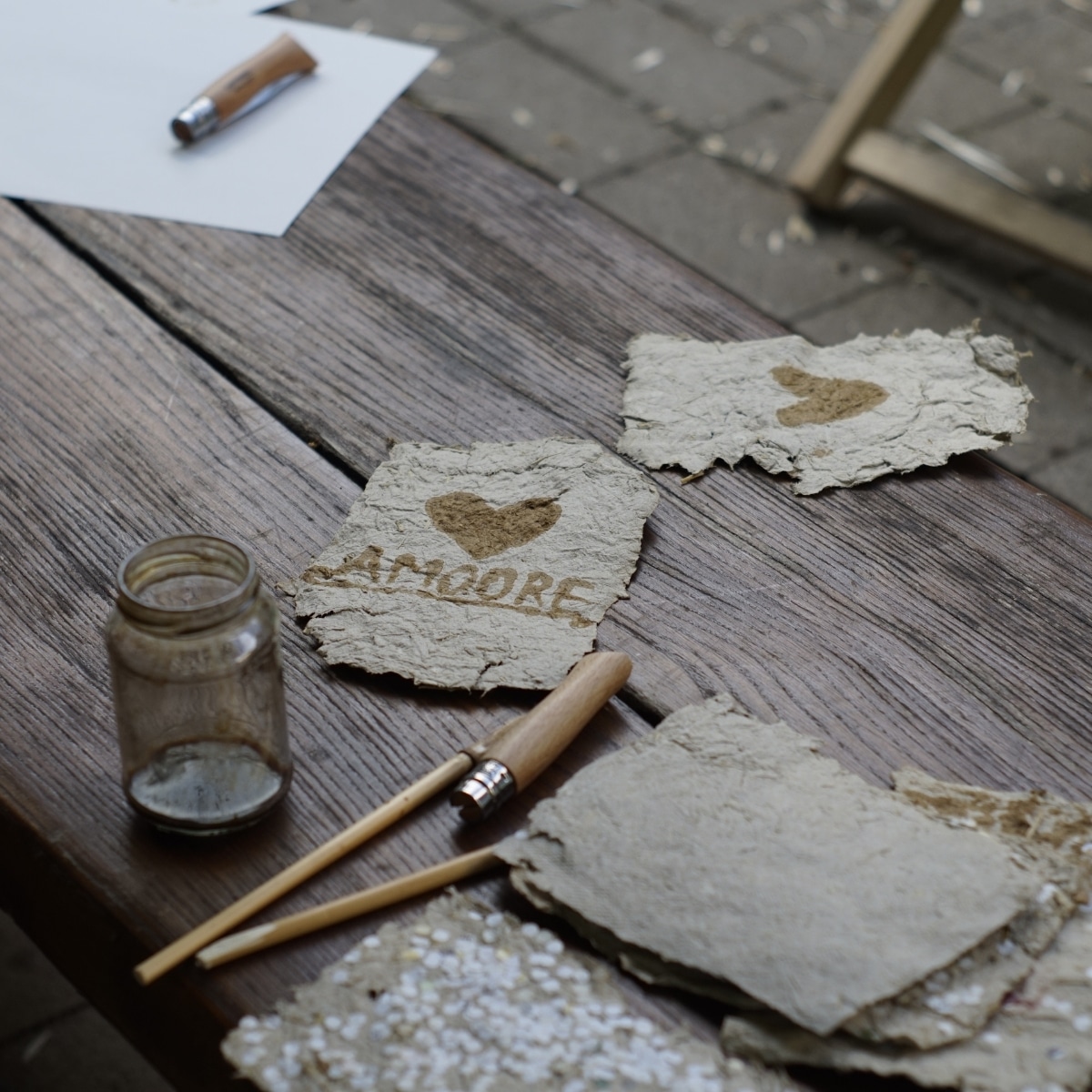 Handgemachtes Papier mit Herzmotiv und Schriftzug.