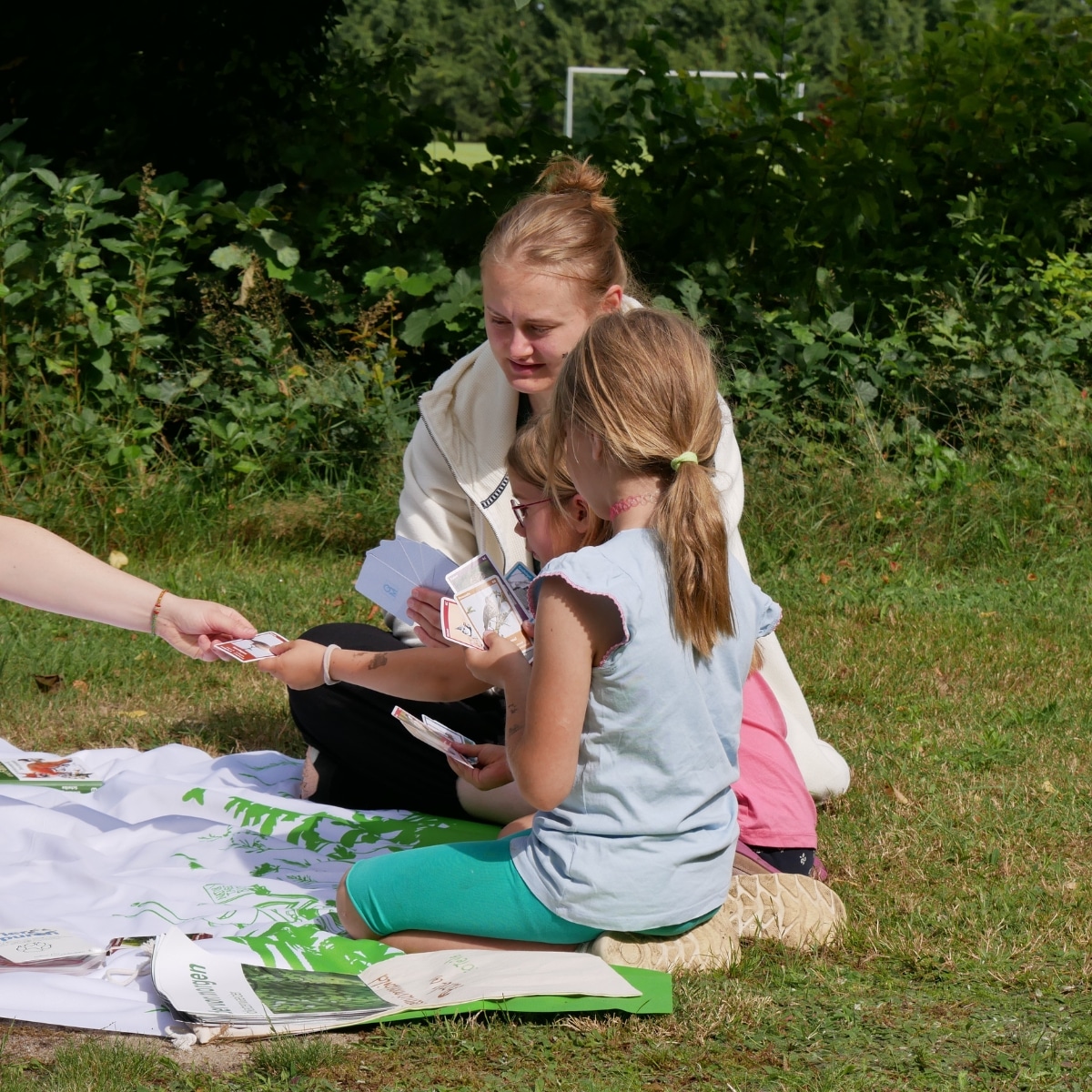 Kinder spielen Karten im Freien