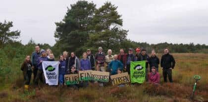 Gruppe im Moor mit Bannern und Schildern
