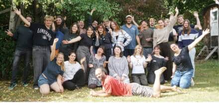 Lachende Gruppe posiert draußen für Foto.