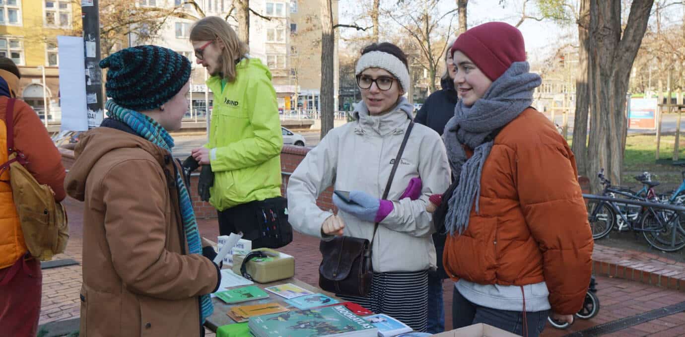 Menschen im Gespräch mit Infostand